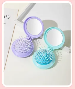 Close-up of cute purple and cyan foldable round hairbrushes with built-in mirrors