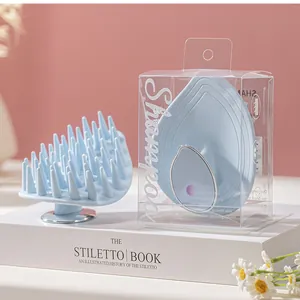 Detailed view of leaf-shaped scalp massager brush and its transparent retail packaging.