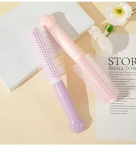 Close-up of cute cat paw handle hairbrush in pink and purple colors for hair styling