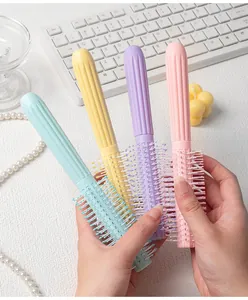 Close-up of four macaron-colored hairbrushes for professional styling and curling hair