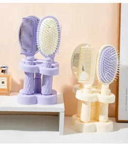 Detailed view of the 4-piece hairbrush set with massage brush and mirror on a stand