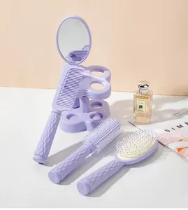 Detailed close-up of the professional four-piece purple hairbrush styling set with mirror