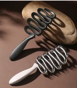 Detail of two speckled ribbon hairbrushes with boar bristles on a natural stone background