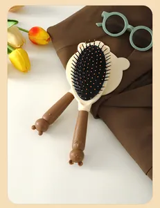Detailed view of the cute cartoon bear shaped hairbrush set with scalp massage bristles