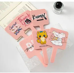 Close-up of pink portable hand mirrors with cute cartoon prints and quotes