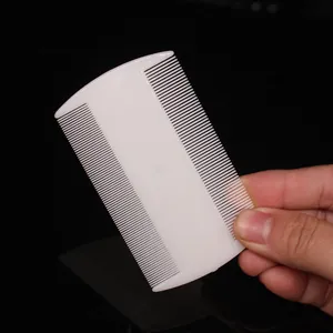 Detailed close-up view of a white double-sided plastic flea comb for pet grooming