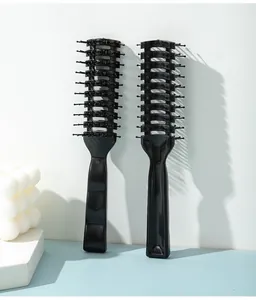 Close-up of two black professional vent hair brushes for men's styling and volume
