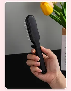 Detailed handheld view showing the compact size of the black folding travel hair comb.