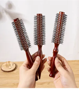 Detailed view of professional red-brown wooden round hair brushes in three sizes