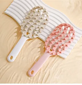 Detail view of pink and beige hollow scalp massage combs in a water ripple setting