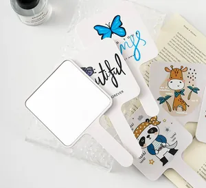 Close-up detail of various printed handheld square mirrors with cute cartoon patterns.