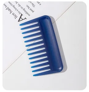 Gros plan de haute qualité d'un peigne bleu à dents larges sur un livre élégant.