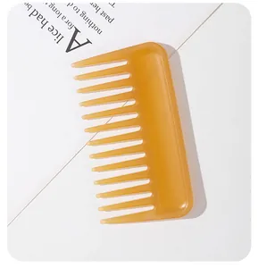 Détail macro montrant les dents larges d'un peigne à cheveux en plastique ambre.