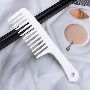 Detailansicht eines weißen grobzinkigen Kamm mit ergonomischem Griff