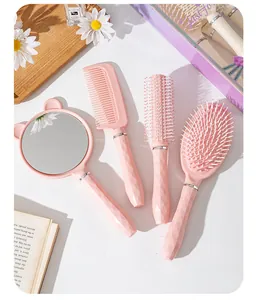 Vista dall'alto di un set di 4 spazzole per capelli rosa con manici sfaccettati e specchio