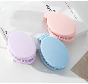 Portable folding hairbrushes with mirrors in pink, blue, and purple pastel colors