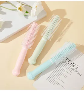 Detail showing three pastel cat paw round hairbrushes with soft nylon bristles on a table.