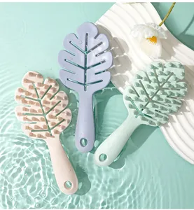 Detail view of leaf-shaped shampoo brushes in pastel colors with silicone scalp massaging teeth.