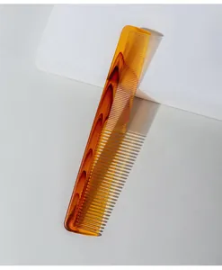 Detailed view of an amber fine-tooth plastic comb for professional hair styling