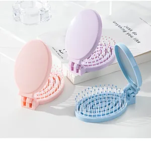 Detail showing three colors of portable folding hair brushes with built-in mirrors.