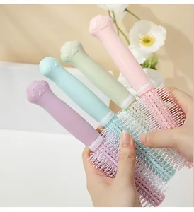 Detailed macro view showing a collection of four pastel-colored cat paw round hairbrushes.