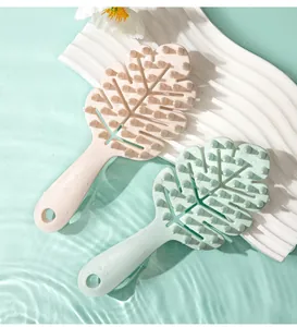 Detail of leaf-shaped scalp massagers in pink and green on a water-themed background
