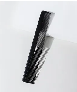 Detailed view of a black fine-tooth styling hair comb against a minimalist white background