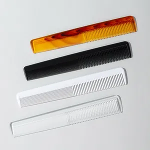 Set of four plastic fine-tooth hair combs in amber, black, white, and clear finishes