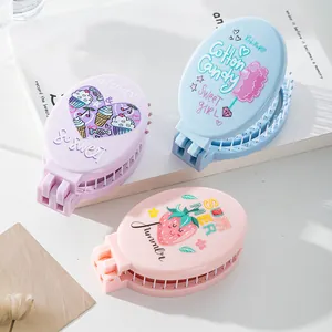 Compact portable folding hairbrush with mirror featuring cute cartoon strawberry prints for travel