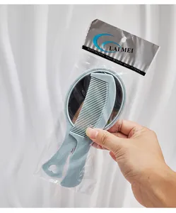 Detailaufnahme eines tragbaren hellblauen Kamm- und Spiegel-Sets in Plastikverpackung.