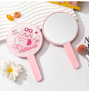 Detailed view of a pink portable handheld mirror with a cute turtle cartoon design