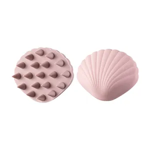 Ergonomic shell-shaped pink silicone scalp massage brush for deep hair cleaning.