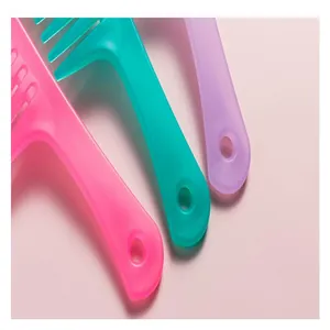 Gros plan de peignes à dents larges translucides et colorés avec trous de suspension