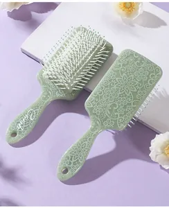 Detail view of green square air cushion hairbrushes with white floral mandala patterns