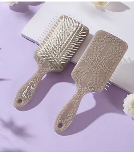 Detailed view of two totem-patterned paddle hairbrushes for scalp massage and detangling.