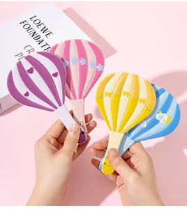 Primer plano de lindos espejos de mano con forma de globo aerostático en colores