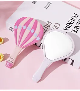 Vista detallada del lindo espejo de mano rosa con forma de globo aerostático para niñas