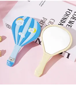 Detalle de lindos espejos de mano con forma de globo aerostático en azul y crema