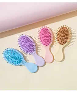 Set of four colorful mini cushion hairbrushes in pastel blue, purple, pink, and beige.