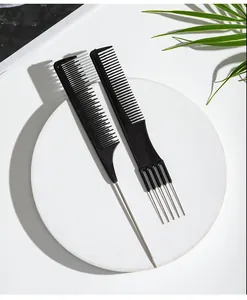 Close-up of professional black hair styling combs with steel needles on white stone