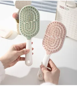 Vista detallada de los cepillos de pelo huecos para masaje del cuero cabelludo en rosa y verde