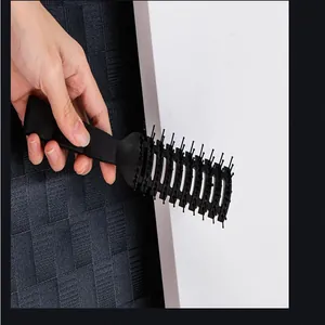Detailed close-up of professional black plastic vent brush for men's hair styling