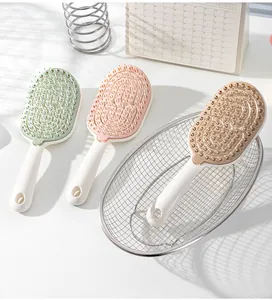 Detalle de tres cepillos de pelo huecos de colores para masaje capilar y peinado