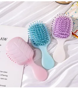 Three pastel mini cushion hair brushes displayed on white silk backdrop