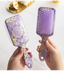 Detailed view of purple glitter hairbrush with mandala pattern and white massage pins