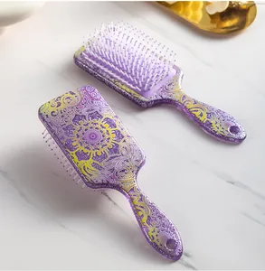 Detailed view of glittery purple cushion hairbrush with intricate mandala patterns.