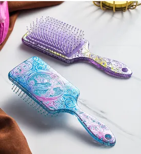 Detailed view of glittery paddle hairbrushes with elegant butterfly and floral prints.