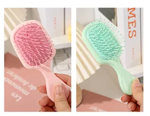 Two mini portable pink and green air cushion hairbrushes for gentle scalp massage