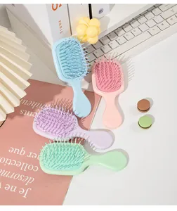 Detailed view of four mini portable air cushion massage hair brushes in lovely pastel colors