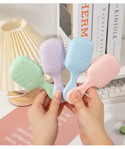 Detailed view of four colorful mini portable air cushion hairbrushes with leaf patterns